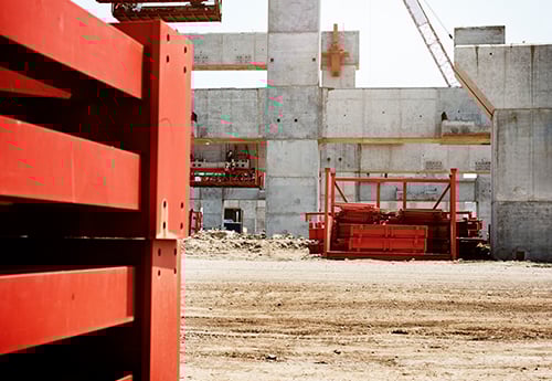 a commercial construction site with concrete walls and temporary trash bins